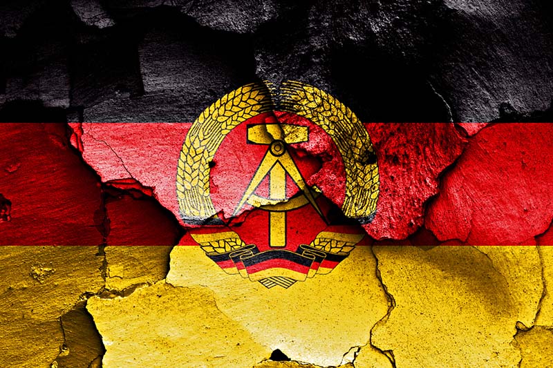 flag of east germany painted on cracked wall