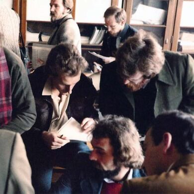 A group of men looking at papers in a library.