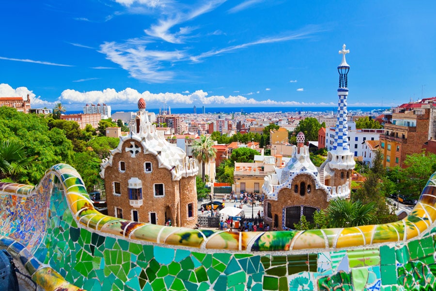 Parc Guell, Barcelona, Spain. Main entrance to Gaudi's Parc Guell and skyline of Barcelona. istock.com/eli_asenova